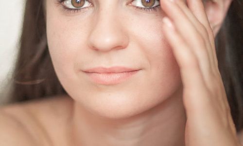 A person sitting calmly with eyes closed in a peaceful setting.