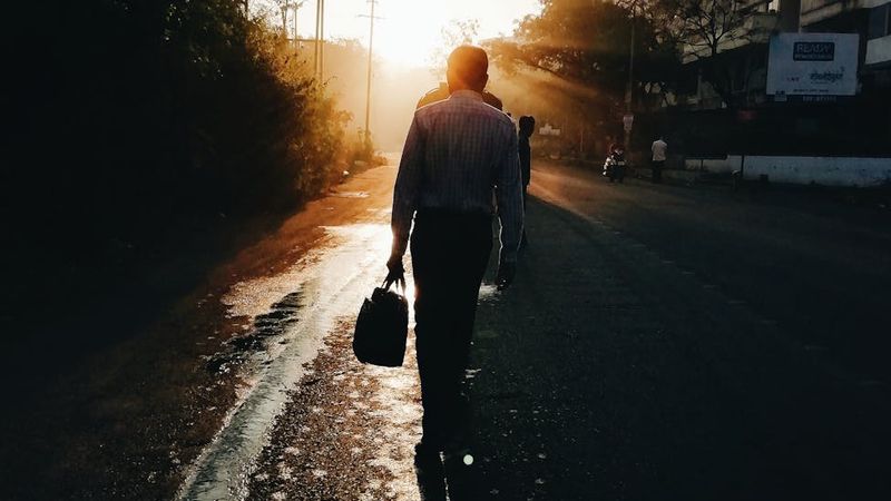 A walking path in a serene park at sunrise, suggesting a daily routine.