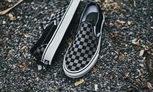 Close-up of comfortable walking shoes on a leafy path.