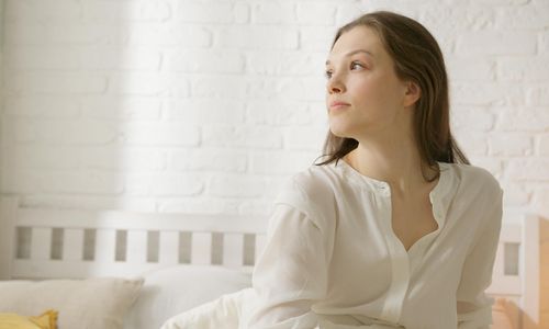 Person doing a gentle seated stretch in a well-lit room.